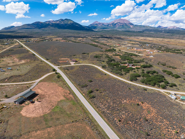14 East Spring Draw Drive, Unit 13 La Sal, UT 84530 - Photo 2 of 17 Expansive rural landscape featuring a paved road, scattered residences, and distant mountains