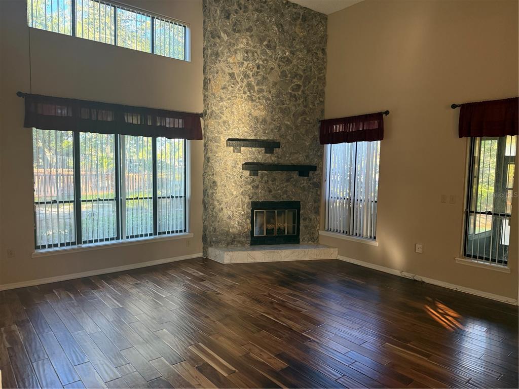 11711 Ridgeview Lane Seminole, FL 33772 - Photo 11 of 30 a view of an empty room with wooden floor fireplace and a window