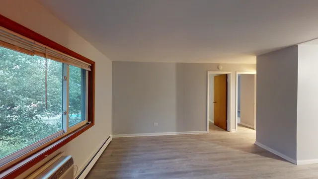 a view of a room with wooden floor and large windows