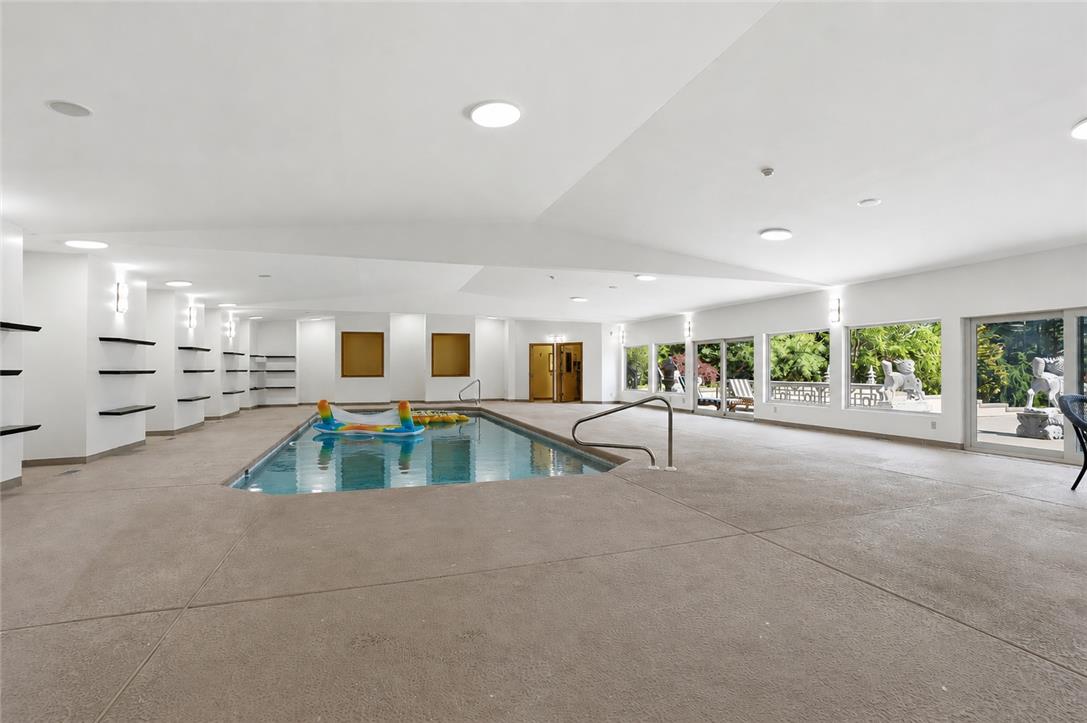 6271 Batman Road Zionsville, PA 18092 - Photo 38 of 100 An indoor pool with expansive windows offers a serene escape, blending relaxation with nature's beauty.