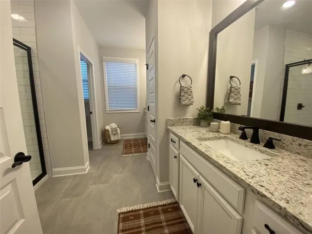 a spacious bathroom with a granite countertop sink and a mirror