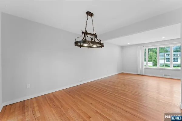 a view of a room with wooden floor fan and window