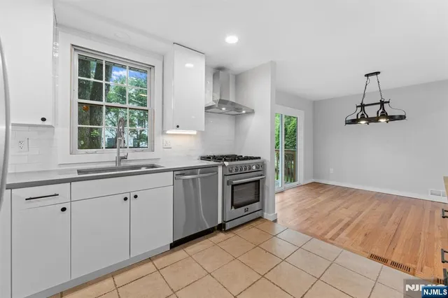 a kitchen with granite countertop a stove a sink and a refrigerator