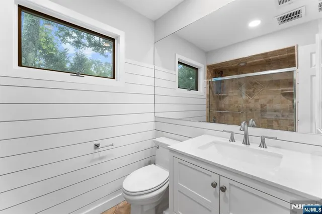 a bathroom with a toilet a sink and mirror