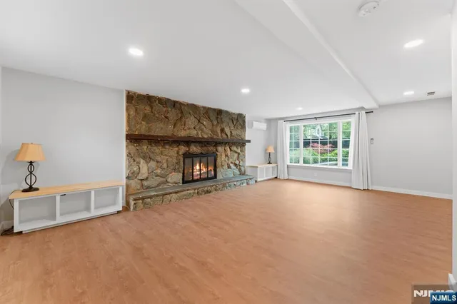 an empty room with windows and fireplace