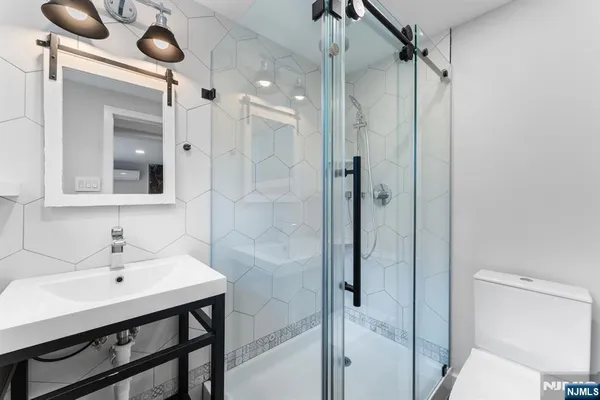 a bathroom with a sink mirror and shower
