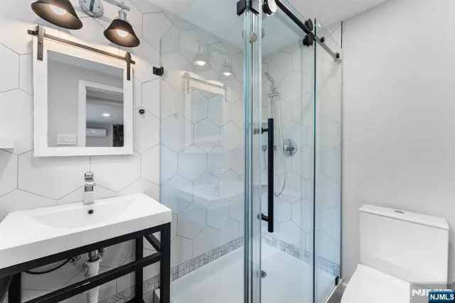 a bathroom with a sink mirror and shower