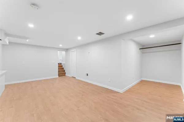 an empty room with wooden floor and natural light