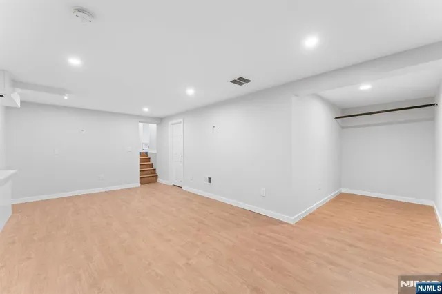 an empty room with wooden floor and natural light