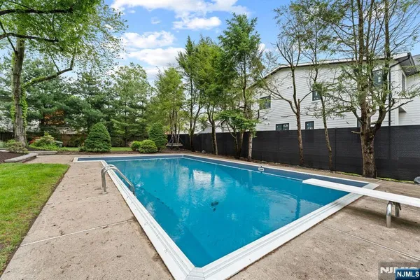 a view of swimming pool on a sunny day with lawn chairs