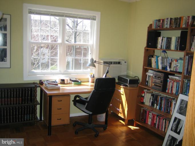 3248 Gunston Road, Unit 724 Alexandria, VA 22302 - Photo 14 of 19 a view of a workspace with bookshelf and a window