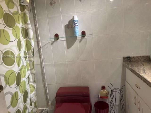 5401 Collins Avenue, Unit 931 Miami Beach, FL 33140 - Photo 18 of 40 a bathroom with a granite countertop sink a toilet and shower curtain