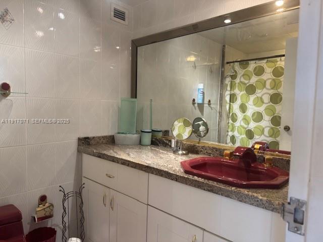 5401 Collins Avenue, Unit 931 Miami Beach, FL 33140 - Photo 19 of 40 a bathroom with a granite countertop sink a toilet and a mirror