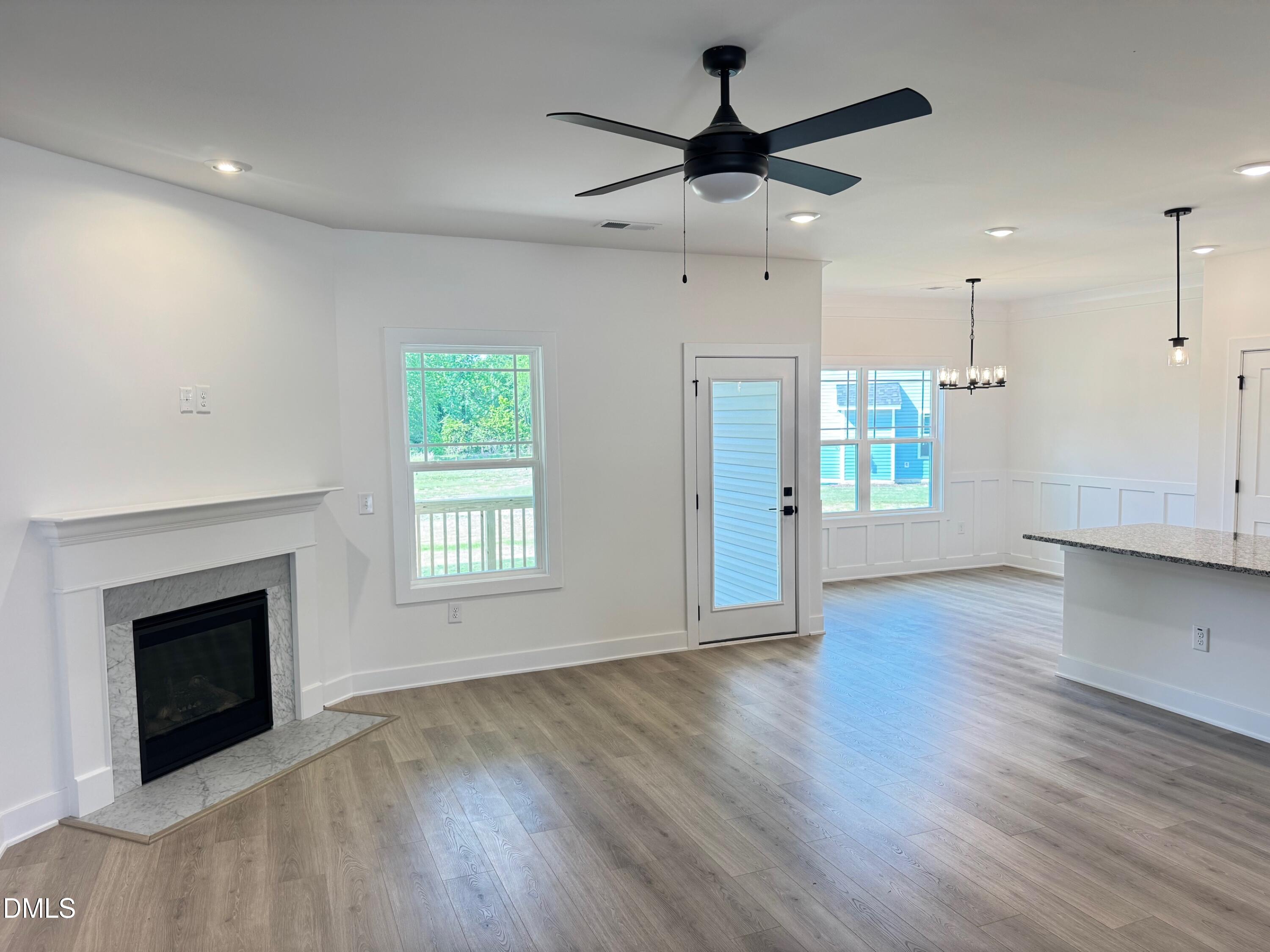 20 Streamline Court Lillington, NC 27546 - Photo 14 of 46 an empty room with wooden floor a ceiling fan a fireplace and windows