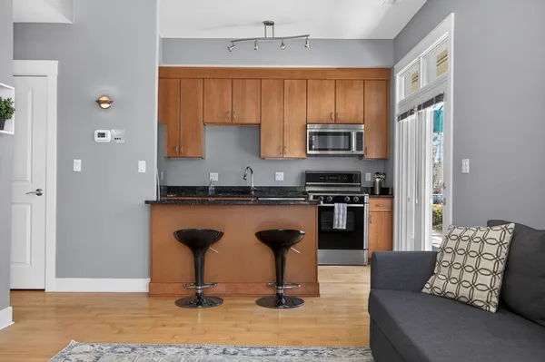 a kitchen with stainless steel appliances kitchen island granite countertop a refrigerator and a stove top oven