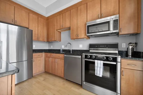 a kitchen with stainless steel appliances granite countertop a refrigerator stove top oven and sink