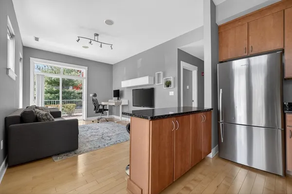 a living room with furniture flat screen tv and a refrigerator