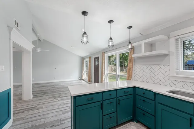 a kitchen with granite countertop a sink and a wooden floor