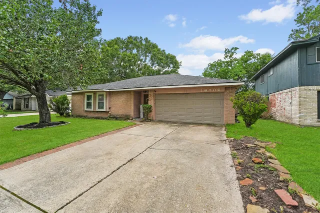front view of a house with a yard and an trees