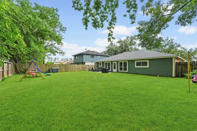a view of a house with a yard and a tree