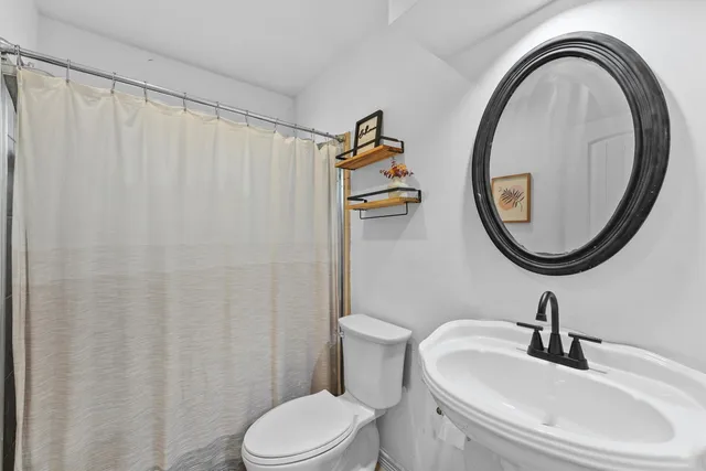 a bathroom with a sink a toilet and a mirror