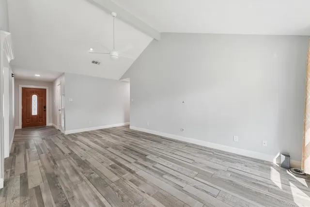 a view of empty room with wooden floor
