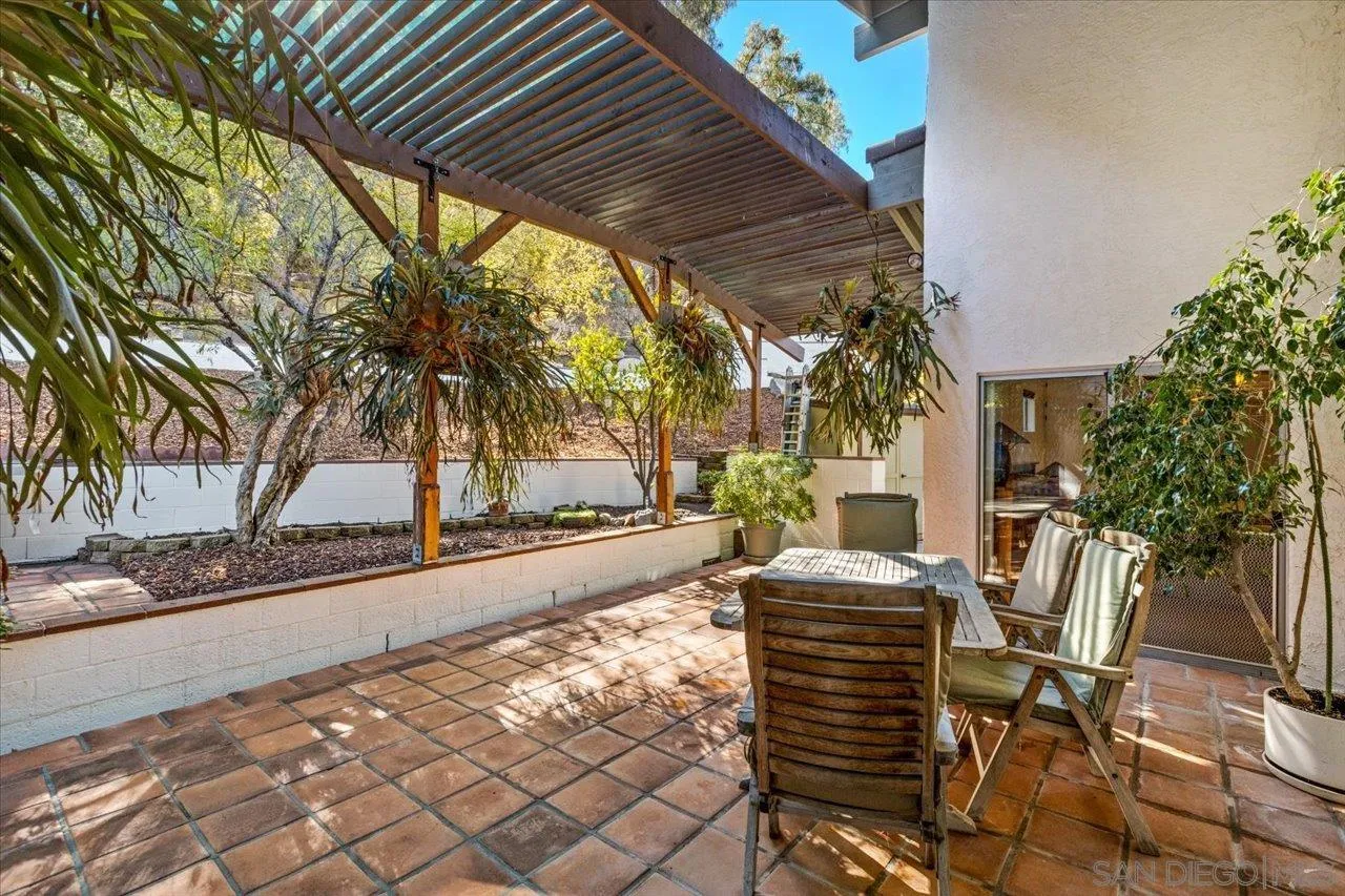 16109 Watt Way Ramona, CA 92065 - Photo 16 of 51 a view of a patio with table and chairs potted plants and palm trees