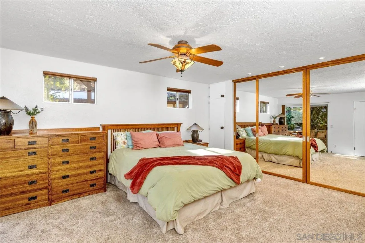 16109 Watt Way Ramona, CA 92065 - Photo 26 of 51 a bedroom with a bed and a chandelier