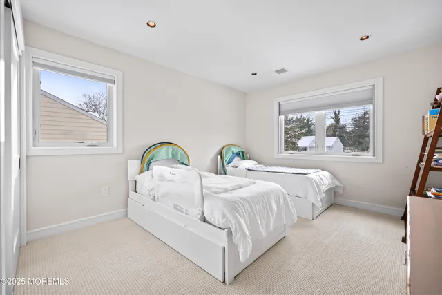 a spacious bedroom with two beds and a window