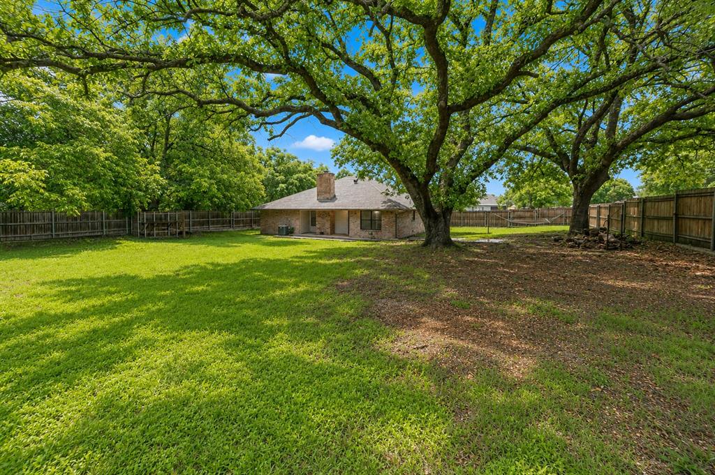1001 Rosebud Drive Azle, TX 76020 - Photo 33 of 36 Expansive backyard featuring a large grass lawn and mature trees