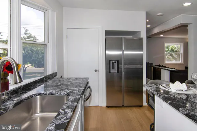a kitchen with stainless steel appliances granite countertop a sink and a refrigerator