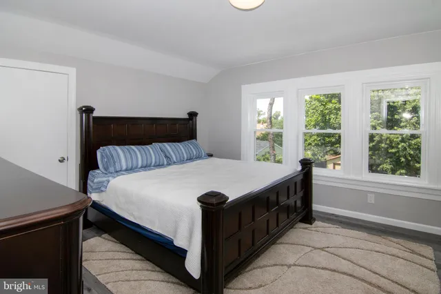 a bedroom with a bed and a mirror on dresser