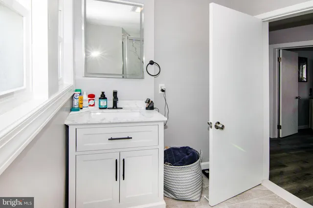 a view of a hallway with wooden floor and cabinet