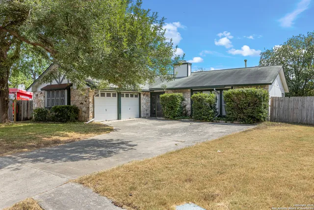 a front view of a house with a yard and a garage