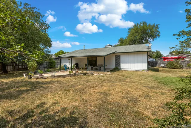 a view of a patio with table and chairs and potted plants with wooden floor and fence