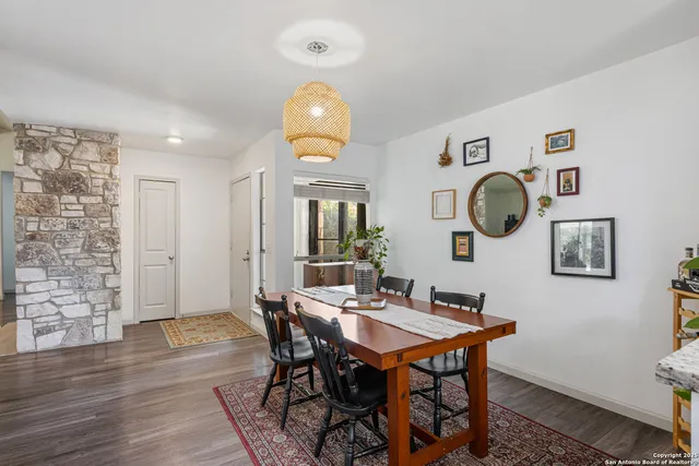 a kitchen with stainless steel appliances granite countertop a stove top oven a sink dishwasher and white cabinets with wooden floor