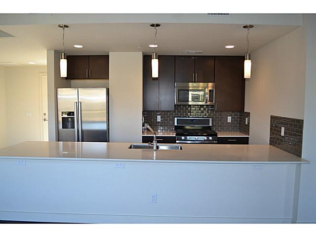 a kitchen with kitchen island a counter top space cabinets and stainless steel appliances