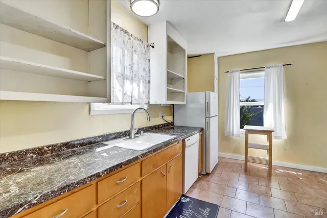 a kitchen with granite countertop a sink and a stove