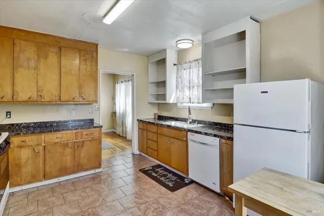 a kitchen with stainless steel appliances granite countertop a refrigerator sink and stove