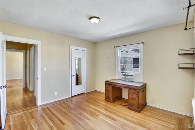 a view of a livingroom with wooden floor and furniture