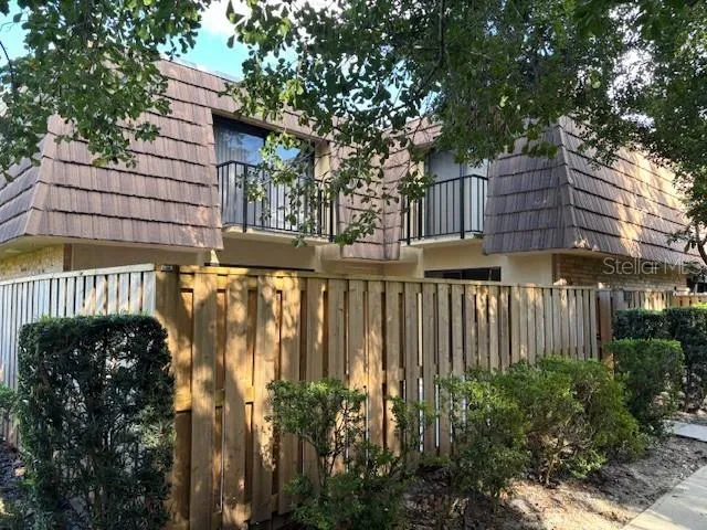 a view of a house with a large window and wooden fence