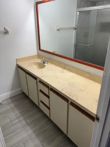 a bathroom with a granite countertop sink and a mirror