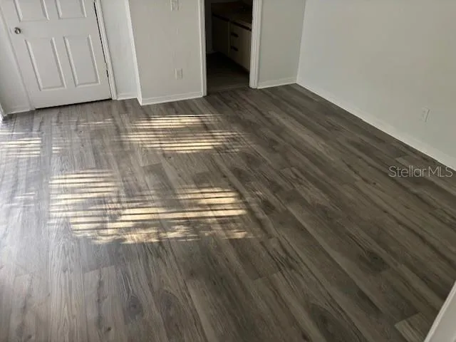 a view of empty room with wooden floor