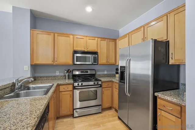 a kitchen with stainless steel appliances granite countertop a stove and a sink