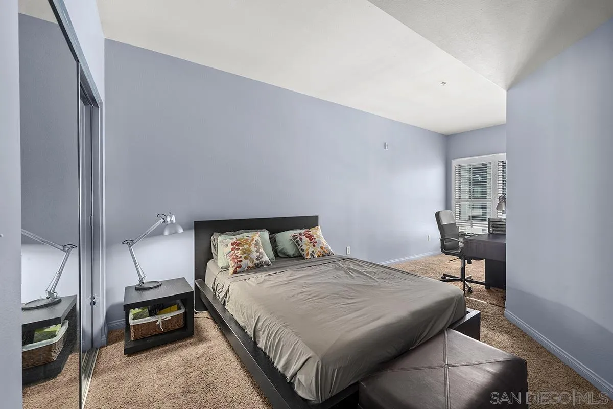 450 J Street, Unit 7071 San Diego, CA 92101 - Photo 14 of 33 a bedroom with a bed and a chandelier