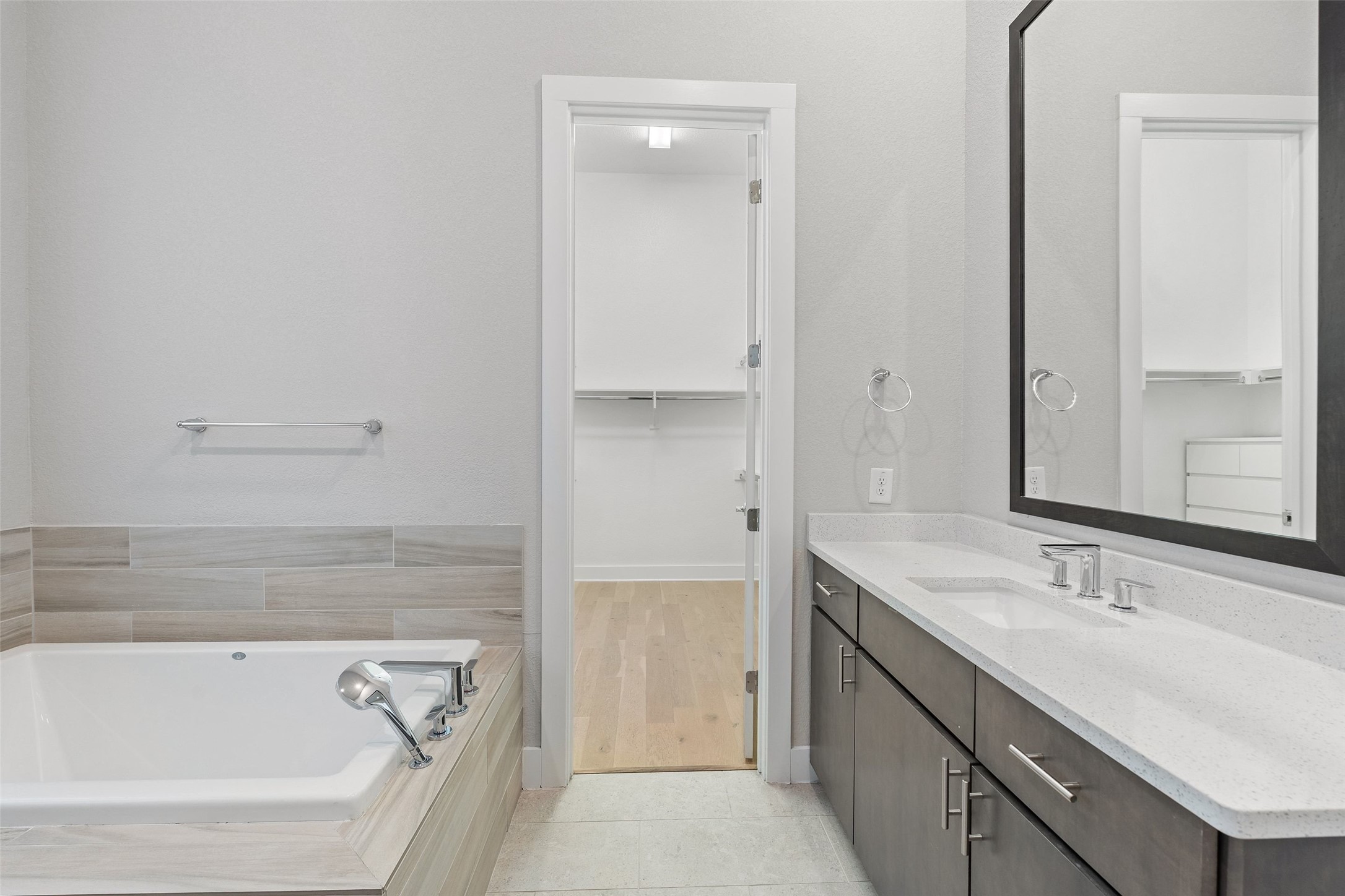 6104 Florencia Lane Austin, TX 78724 - Photo 21 of 31 Bathroom featuring a walk in closet, vanity, a bath, and light tile patterned floors