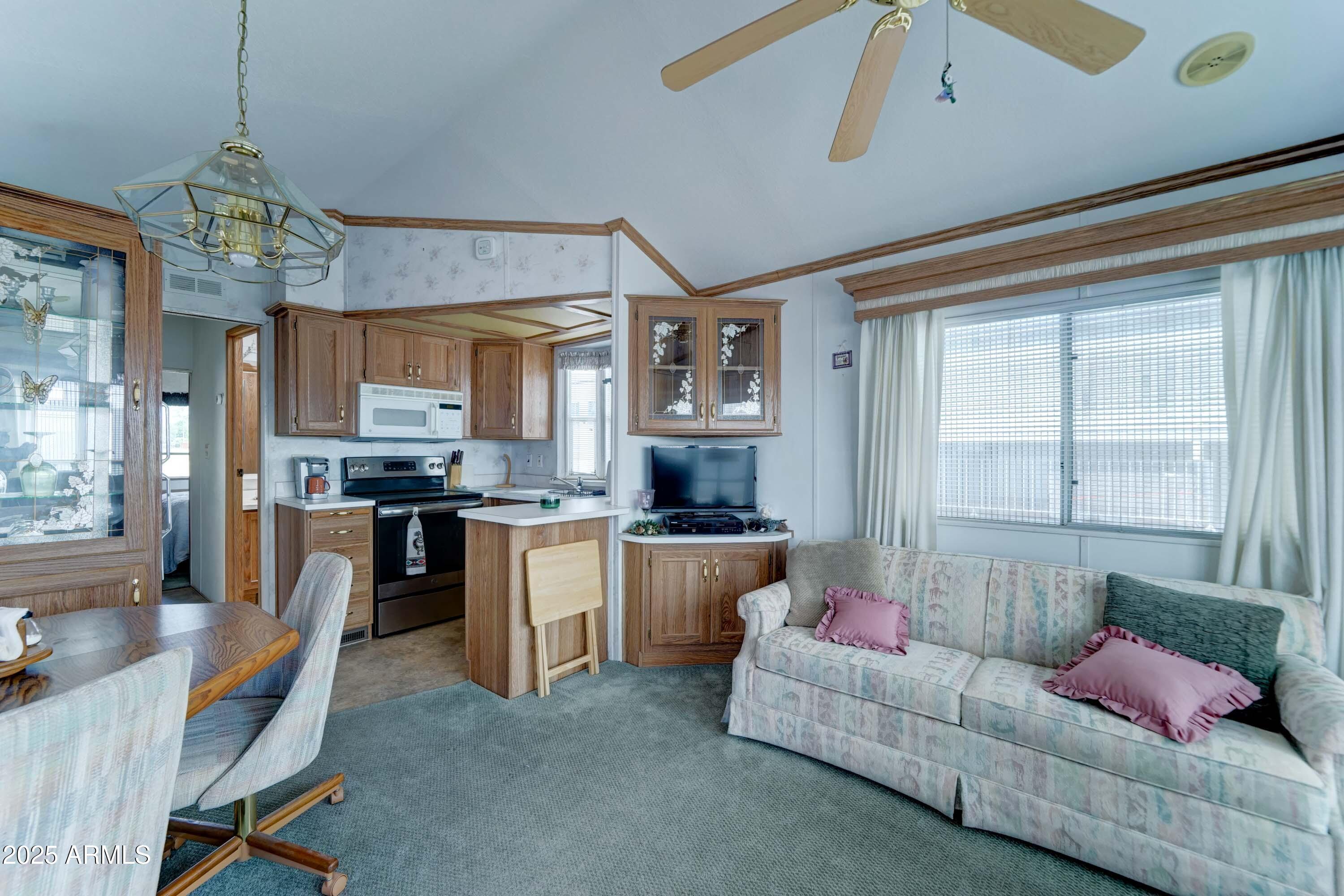 111 South Greenfield Road, Unit 822 Mesa, AZ 85206 - Photo 6 of 25 a living room with kitchen island furniture and a chandelier