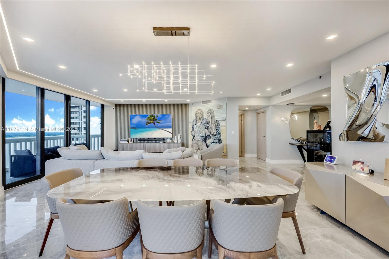 2000 Island Boulevard, Unit 2507 Aventura, FL 33160 - Photo 5 of 21 a kitchen with kitchen island a white cabinets and chairs