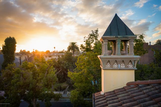 a view of a house with a yard and potted plants