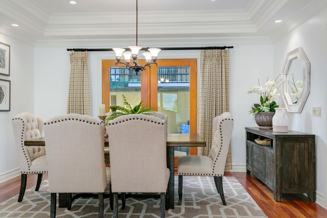 a dining room filled chandelier and wooden floor